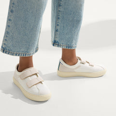 hover | A child modeling The Kids Strap Sneaker in Vanilla Ice. 