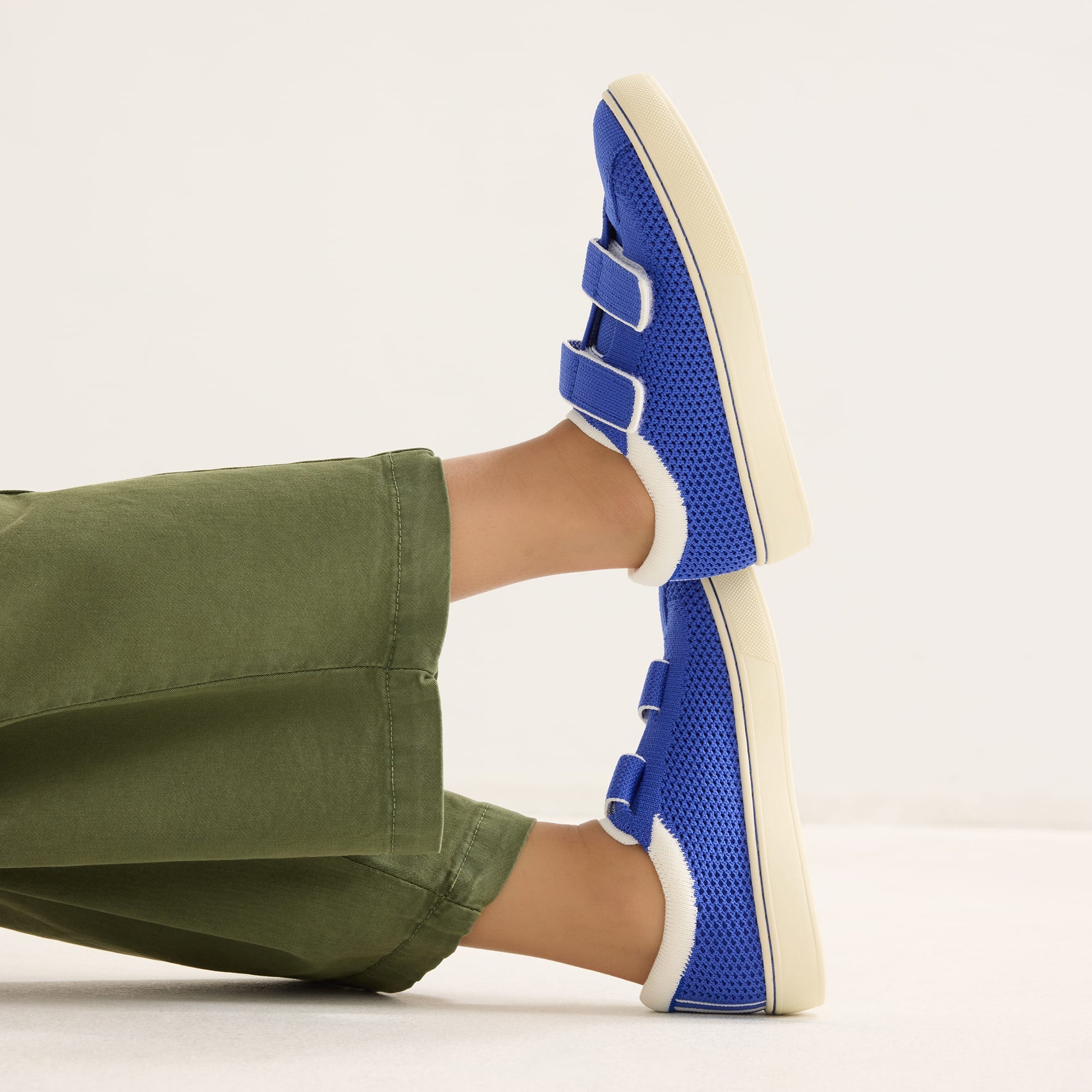 hover | A child modeling The Kids Strap Sneaker in Buoy Open-Knit. 