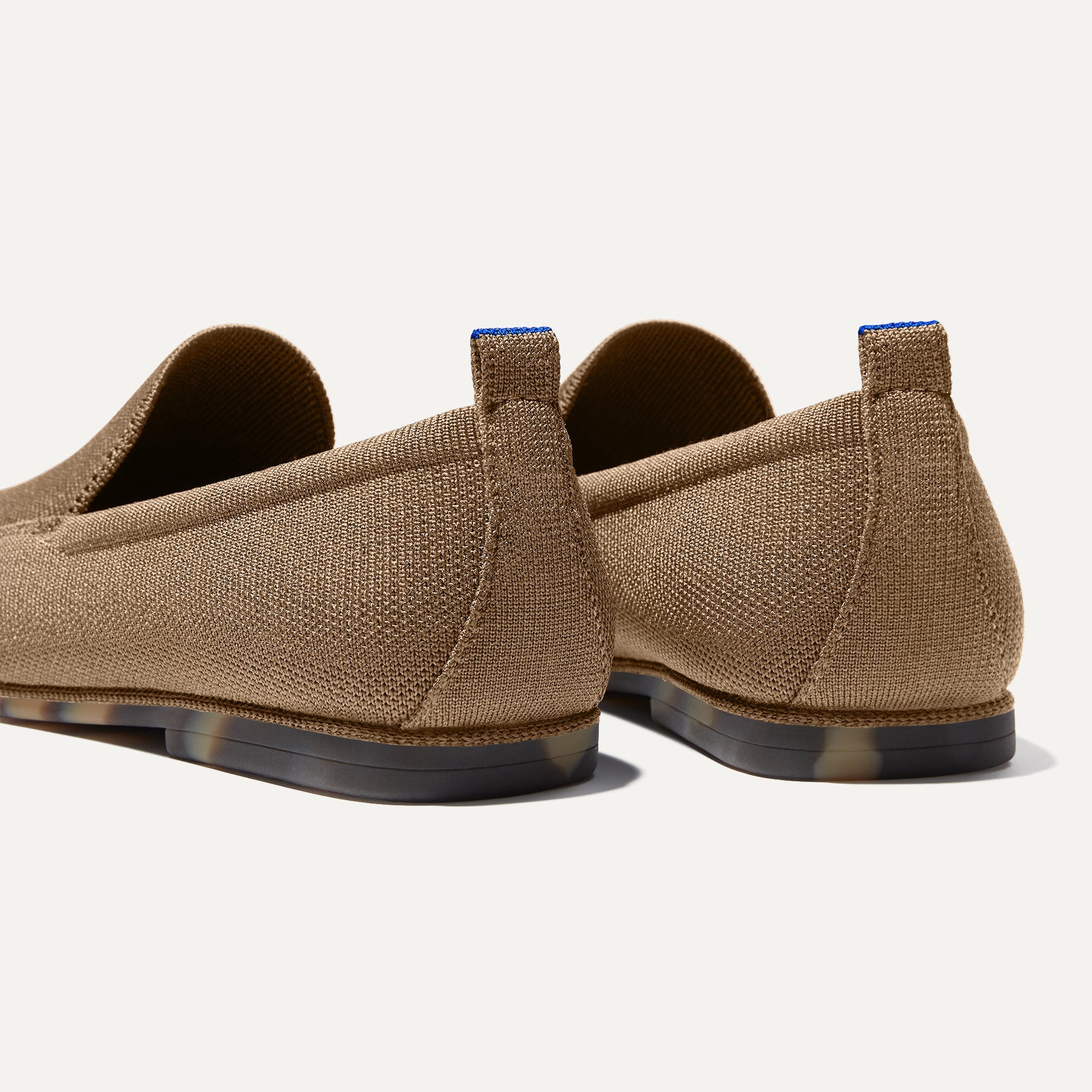 Close up of the heel of The Ravello Loafer in Faded Brown, with Rothy's signature blue halo on the pull tab.