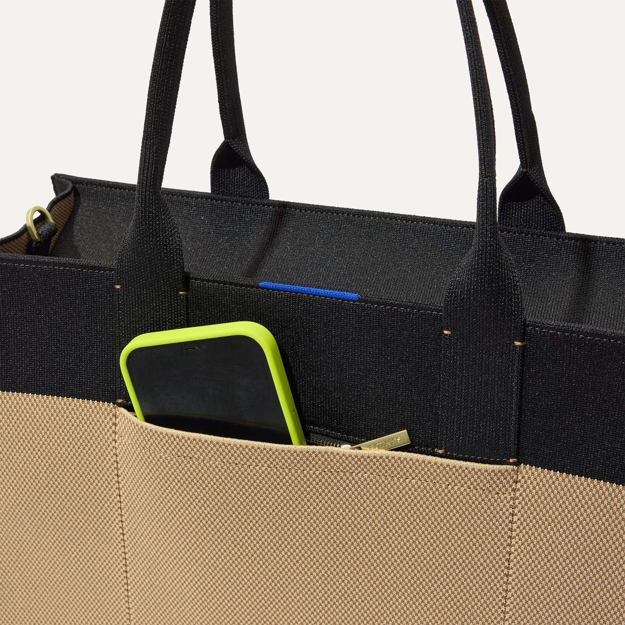 A closeup of The Classic Tote in Tiramisu, focusing on the exterior zip pocket. 