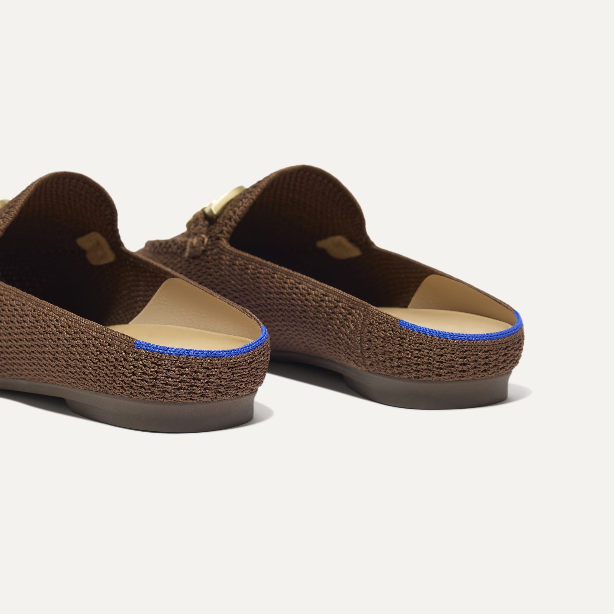 Close up of the heel of The Double Bit Loafer Mule in Cinnamon Raffia-Knit, with Rothy's signature blue halo. 
