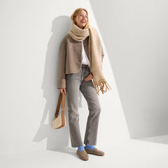 hover | The Casual Crossbody in Vanilla Wafer, carried by its crossbody strap by a model, shown in motion.