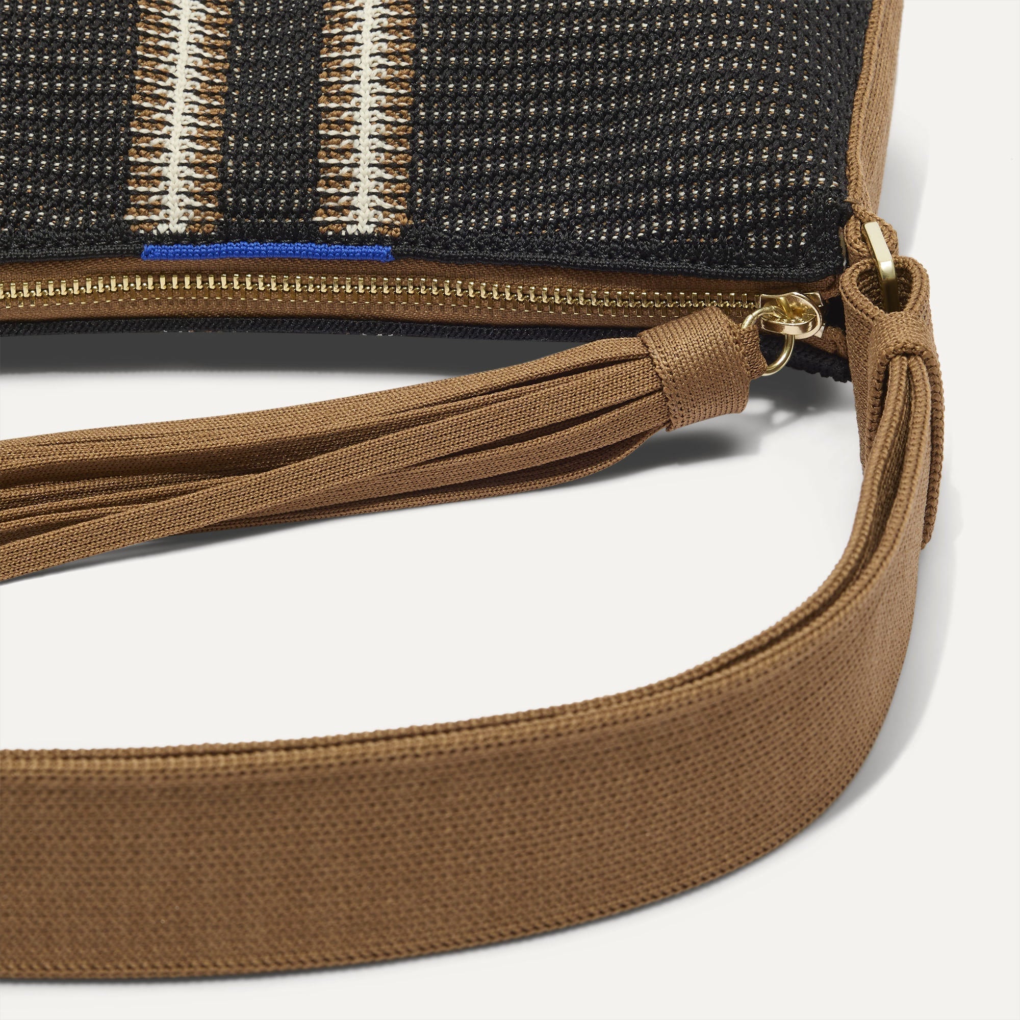 A closeup of The Casual Crossbody in Coffee Market Stripe, focusing on the crossbody strap.