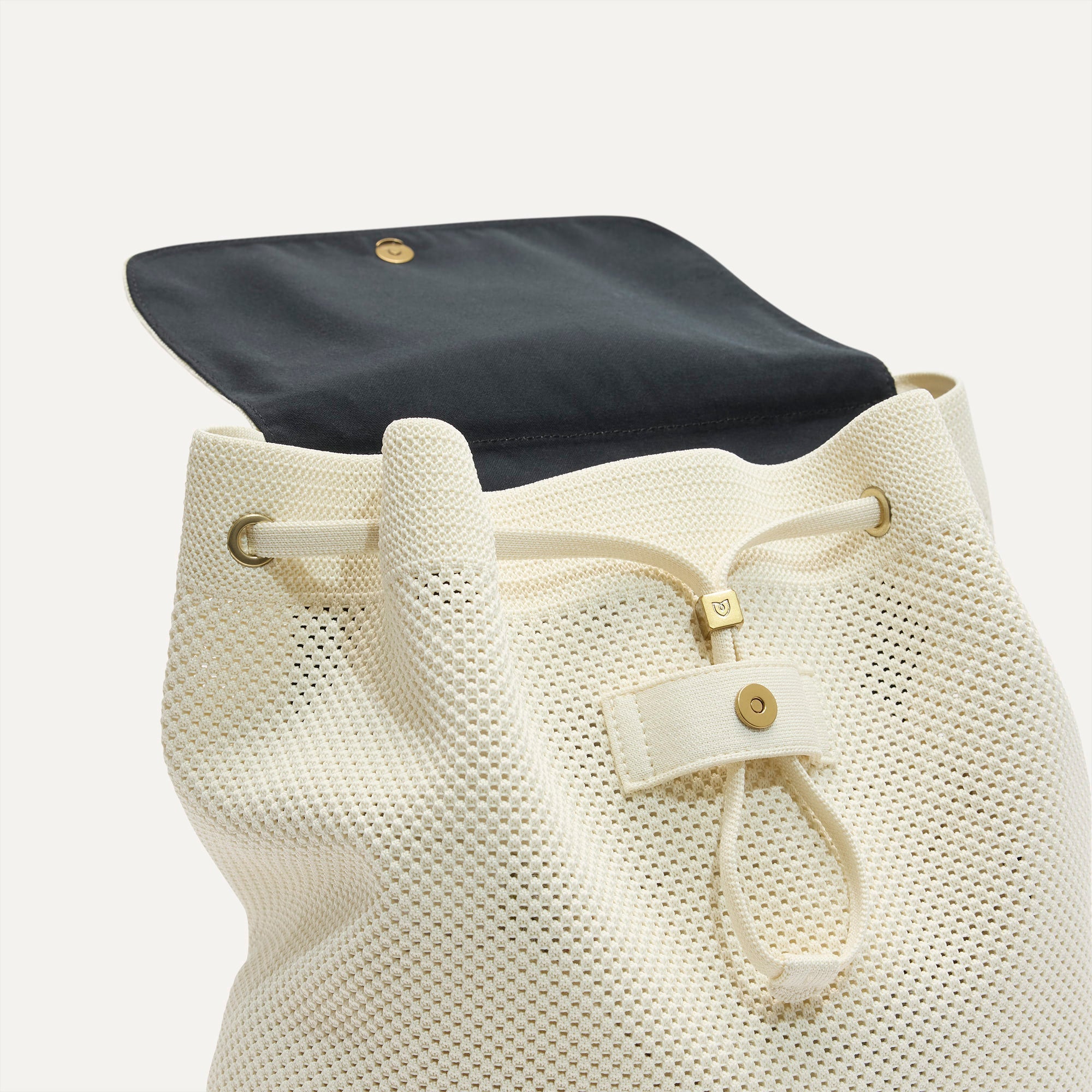A close up of The Cinch Backpack in Coconut Crochet showing the drawstring closure.