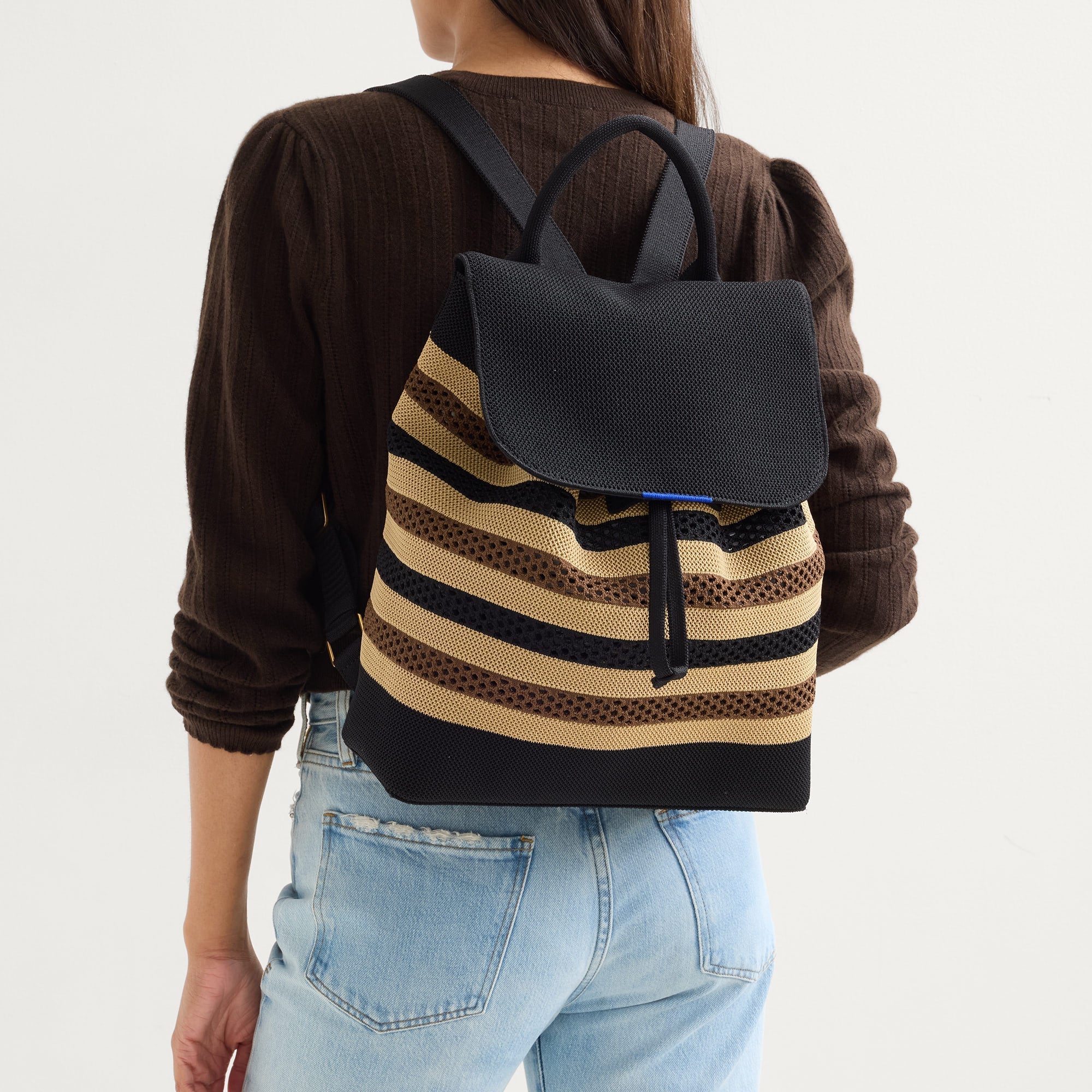 hover  | Model wearing The Cinch Backpack in Mocha Stripe. 