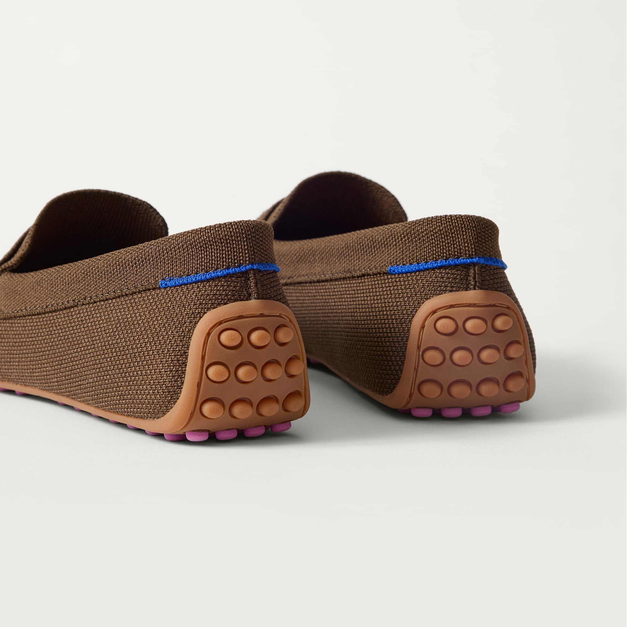 Close up of the heel of The Daily Driver in Dark Morel, with raised peg outsoles and Rothy's signature blue halo. 