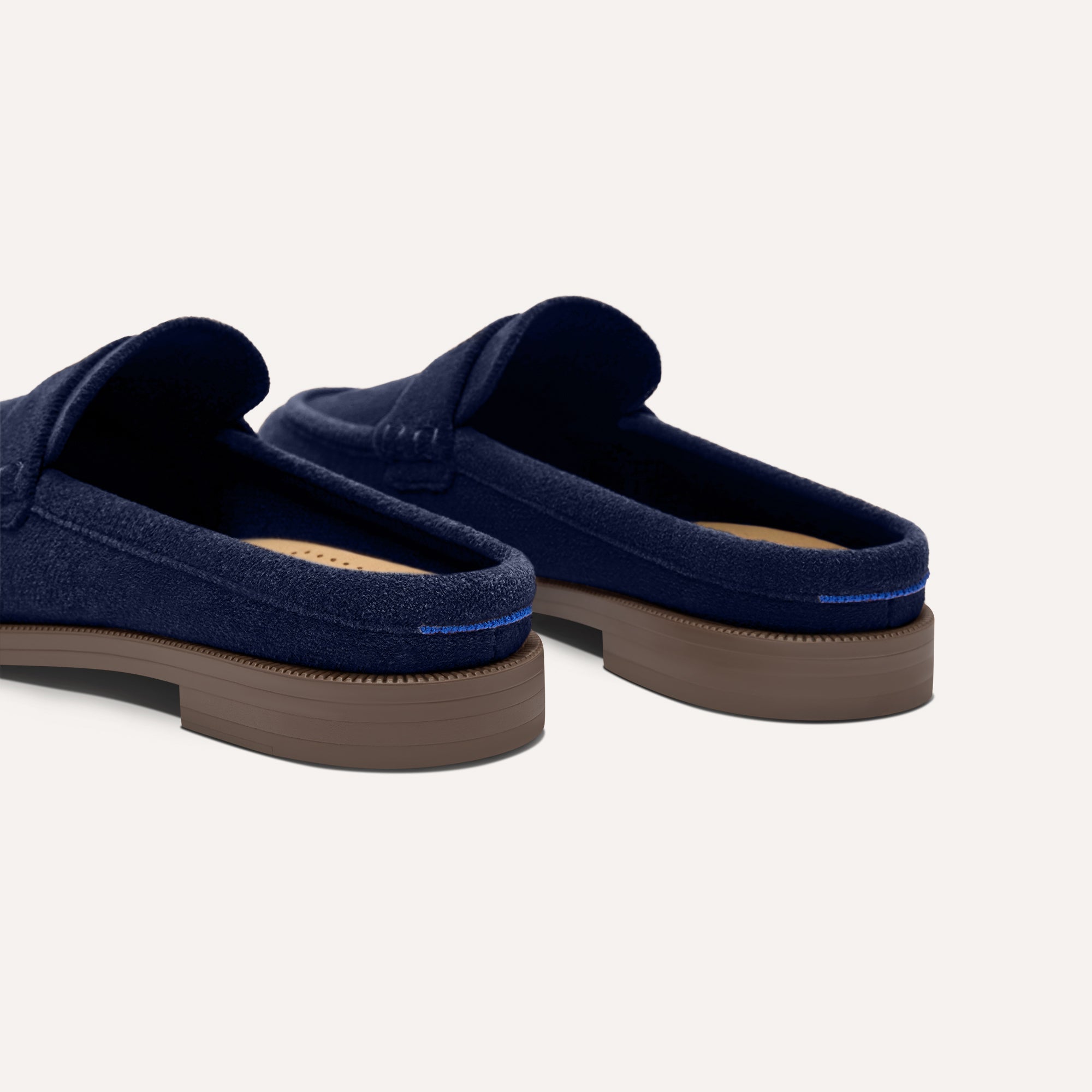 Close up of the heel of The Penny Loafer Mule in ReVelvet Navy, with Rothy's signature blue halo.