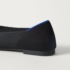 Close up of the heel of The Point III in Black, with Rothy's signature blue halo. 