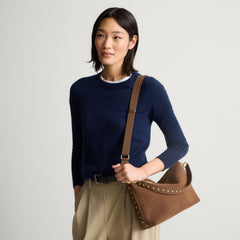 hover | The Daily Crossbody in Revelvet™ Cinnamon, carried over the shoulder of a female model, shown from the right.