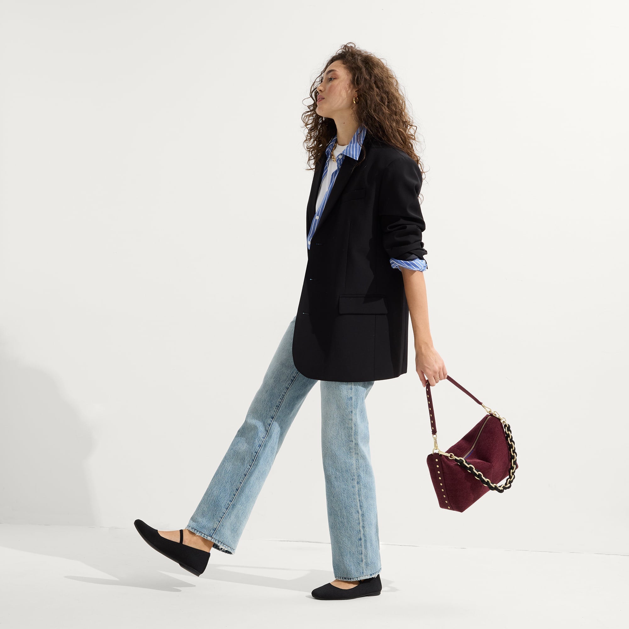 model | Overlay:: Shown with The Shoulder Strap (sold separately). | Alt:: At alternate image of a model carrying The Daily Crossbody in ReVelvet™ Syrah.