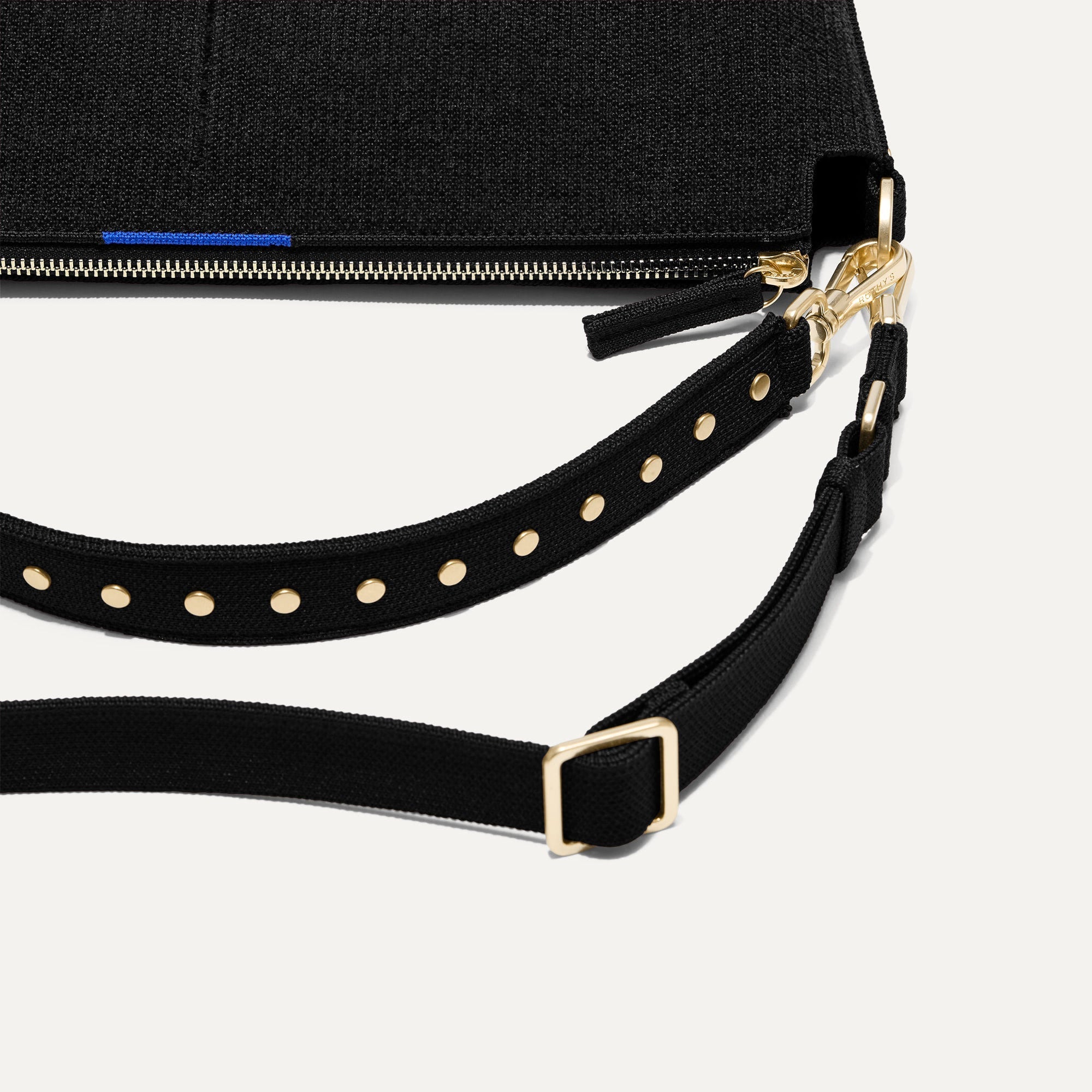 The Daily Crossbody in Revelvet™ Black lying flat, showing the detachable top handle and adjustable crossbody strap.