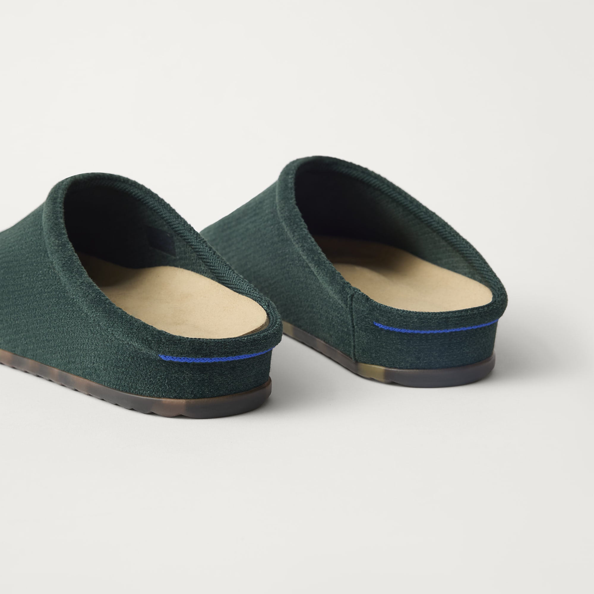 Close up of the heel of The Casual Clog in ReVelvet™ Pine, with Rothy's signature blue halo. 