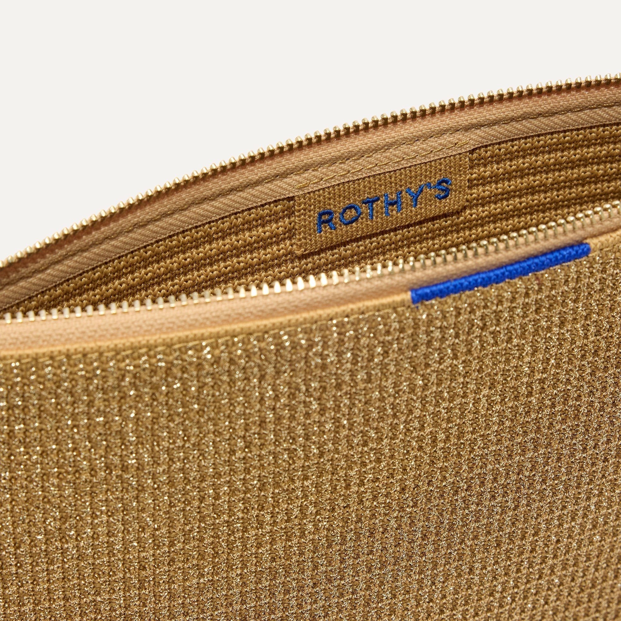 The Convertible Clutch in Glitzy Gold shown open from the top in diagonal view.