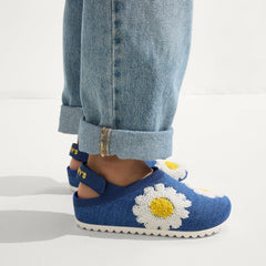 hover | A child wearing The Kids Clog in Indigo Daisy. 