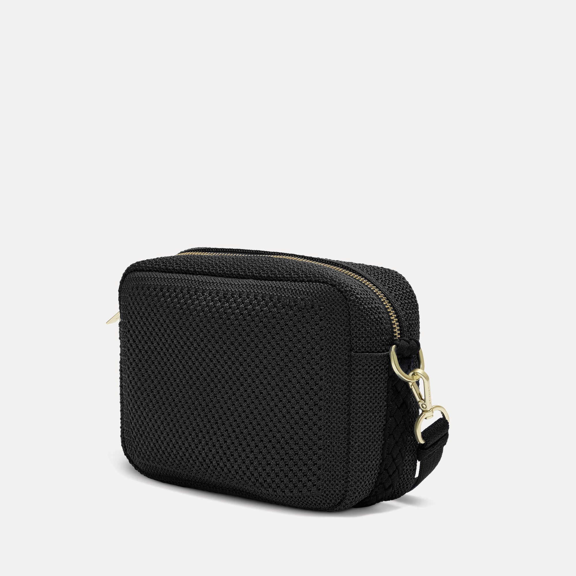 The Crossbody Camera Bag in Black Licorice Open-Knit, shown from the side. 