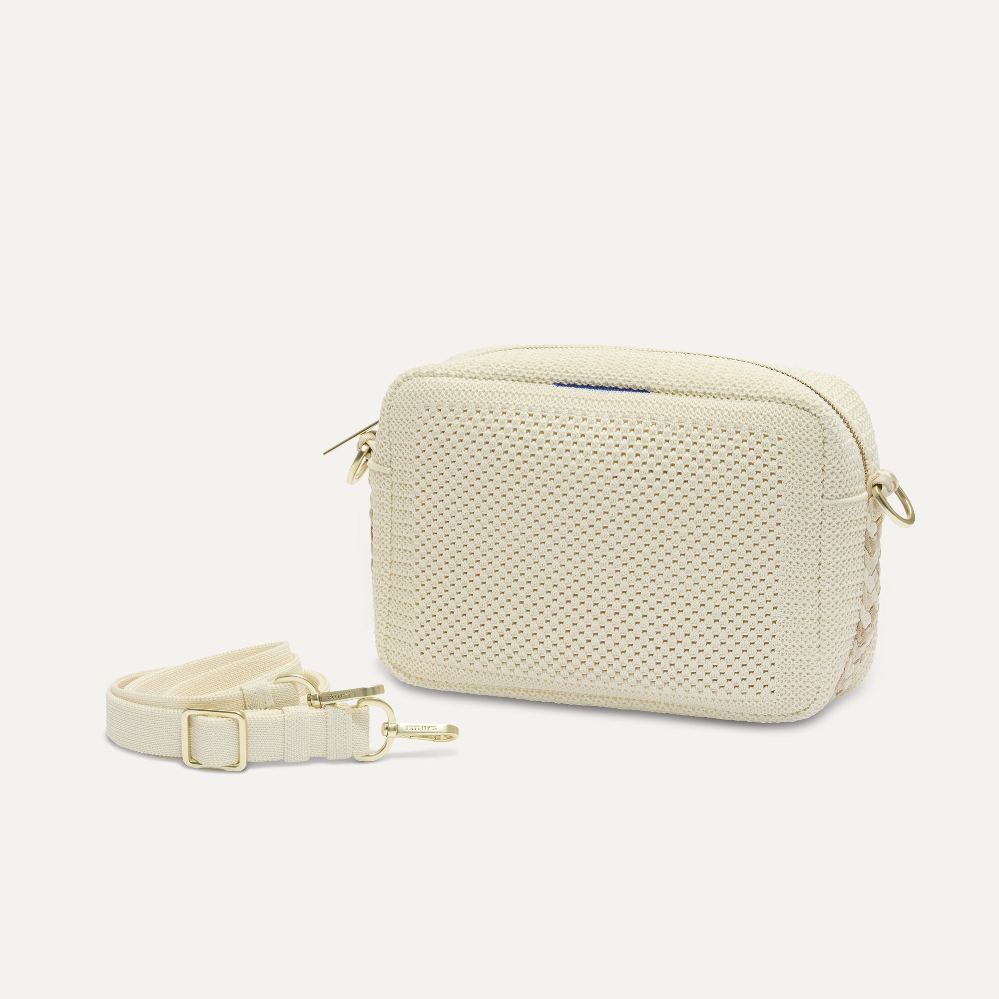 The Crossbody Camera Bag in Cream Twist Open-Knit shown by itself with removable strap. 