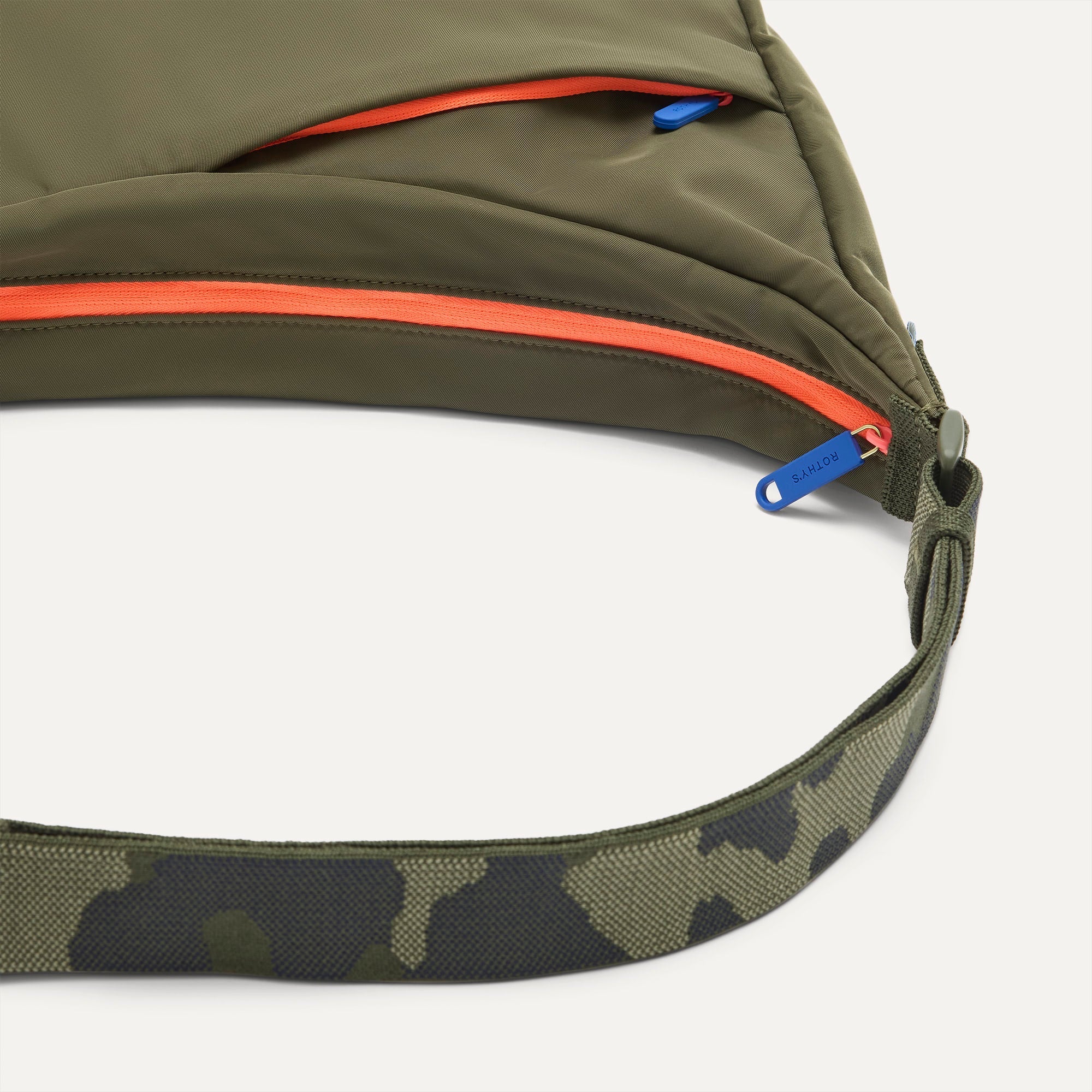 A closeup of The Travel Sling in Forest, showing the smooth zipper closure and soft, flexible handle.