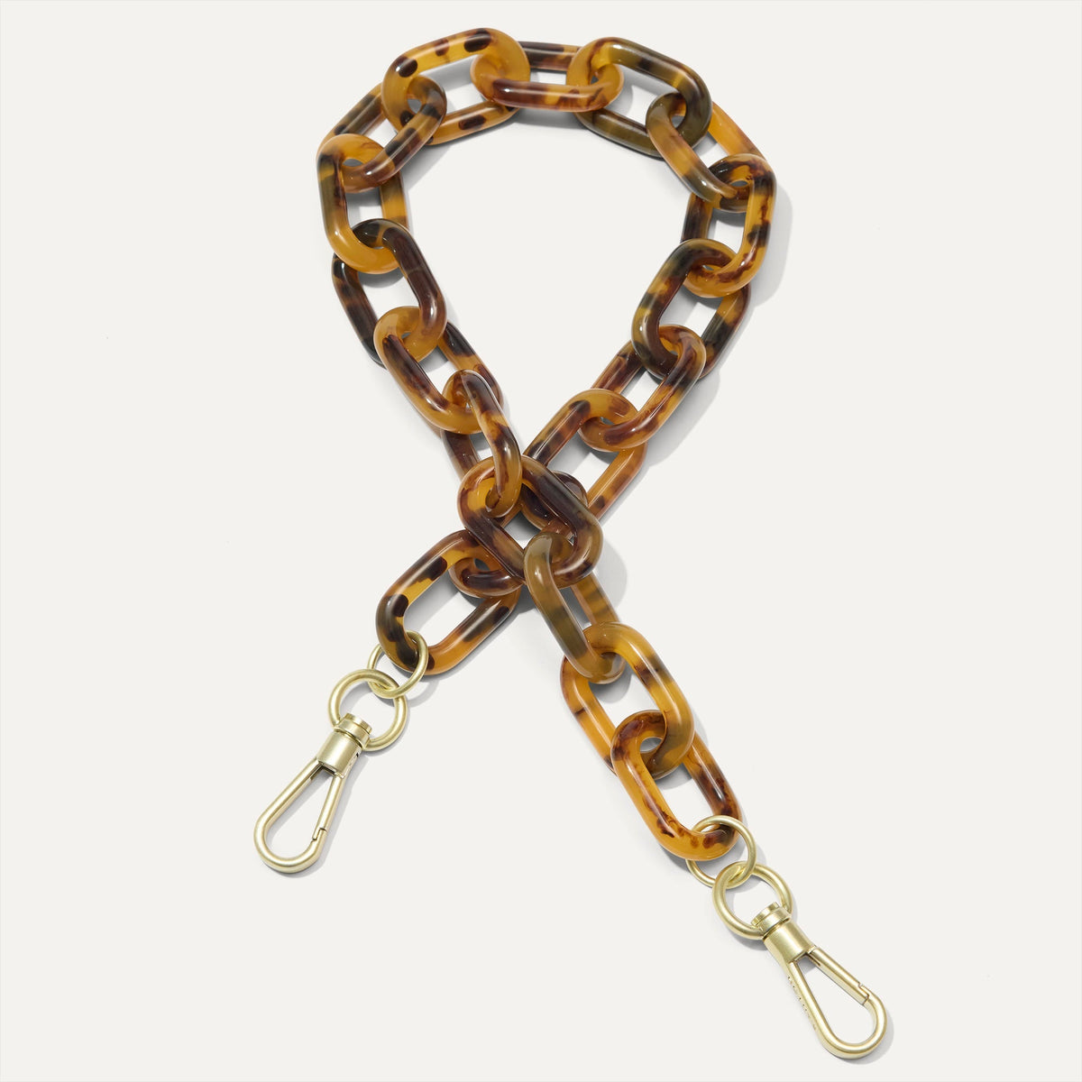 A close-up of The Shoulder Strap in Tortoise Chain, focusing on the end snap hooks. 