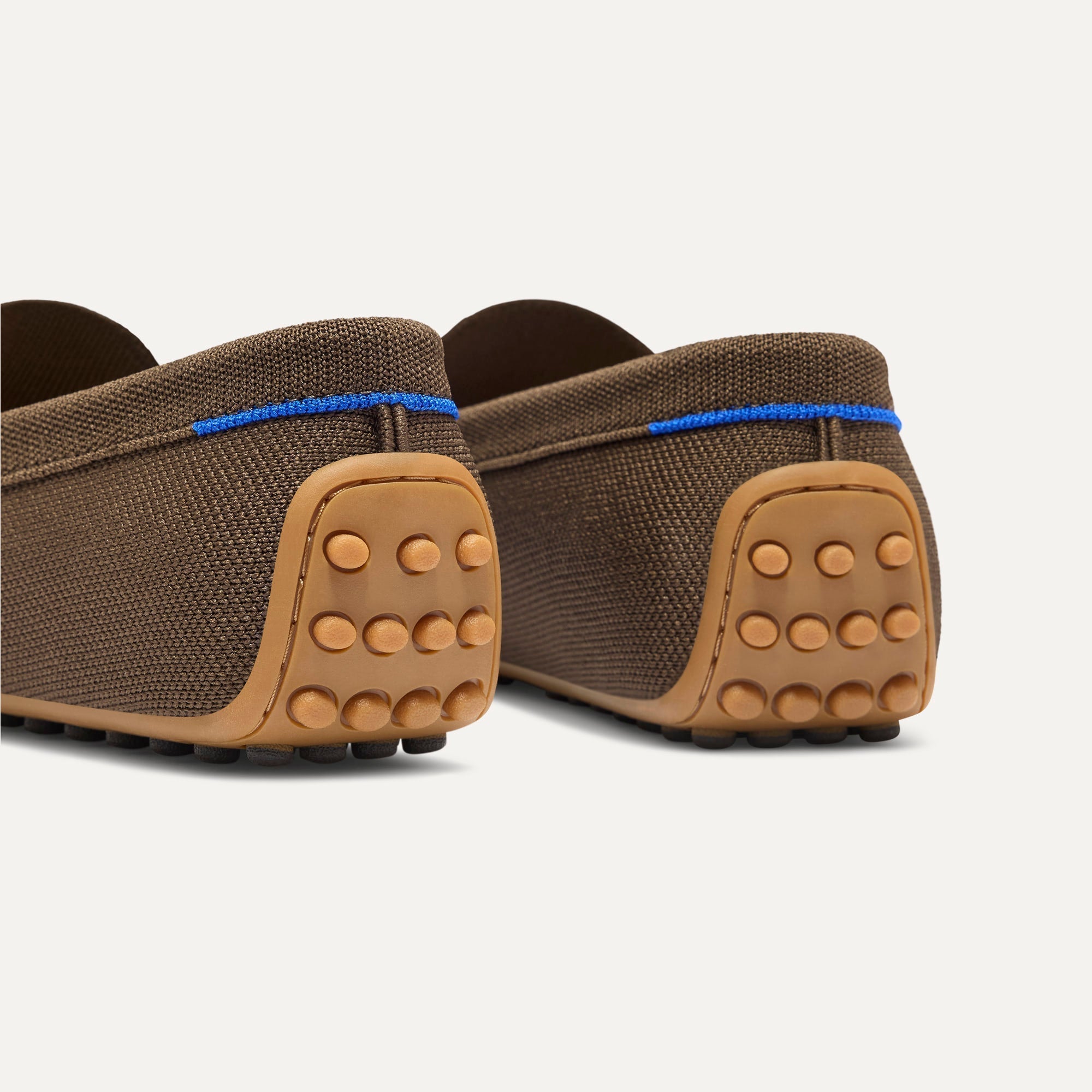 Close up of the heel of The Men's Daily Driver in Dark Roast, with raised peg outsoles and Rothy's signature blue halo. 