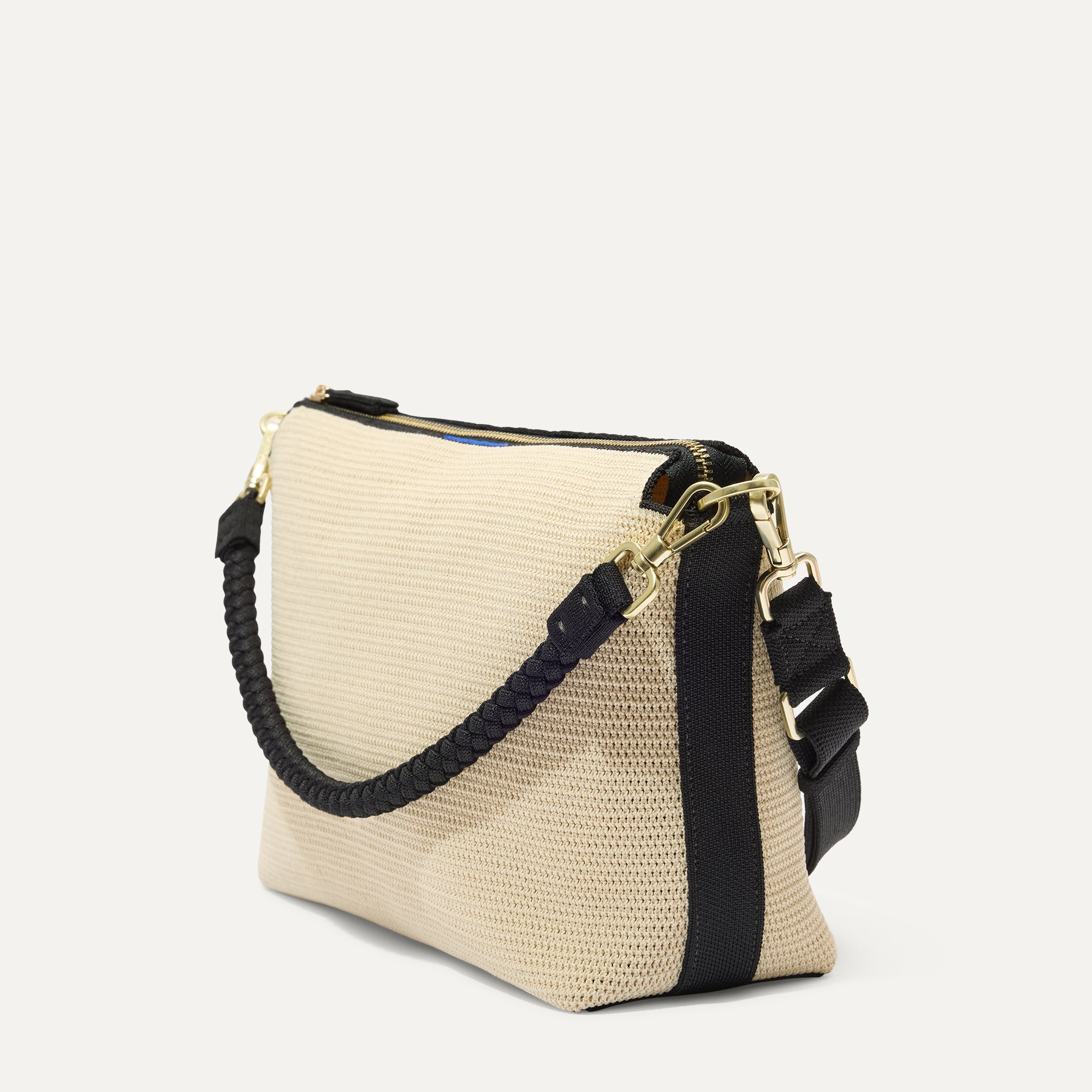 The Daily Crossbody in Black and White Raffia-Knit, shown at a diagonal view from the left.