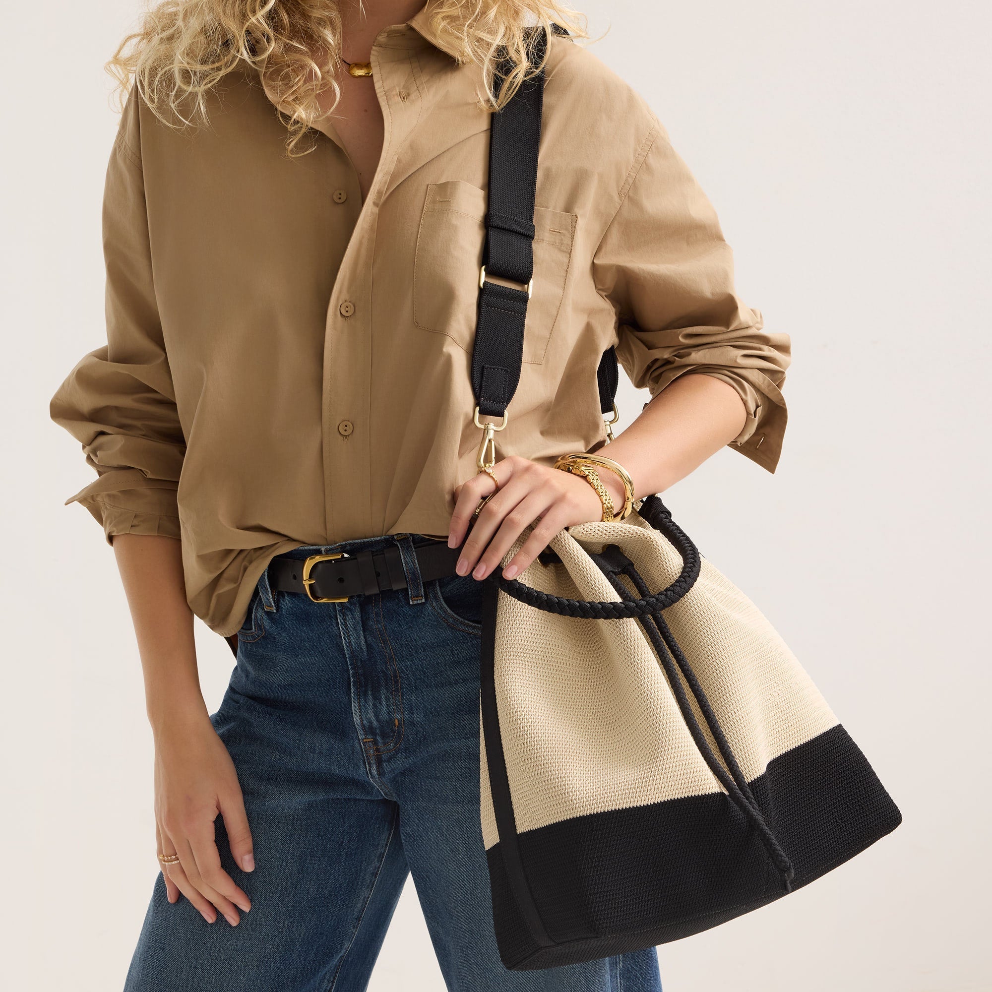hover | Model wearing The Cinch Bucket Bag in Black and White Raffia-Knit shown from the front.
