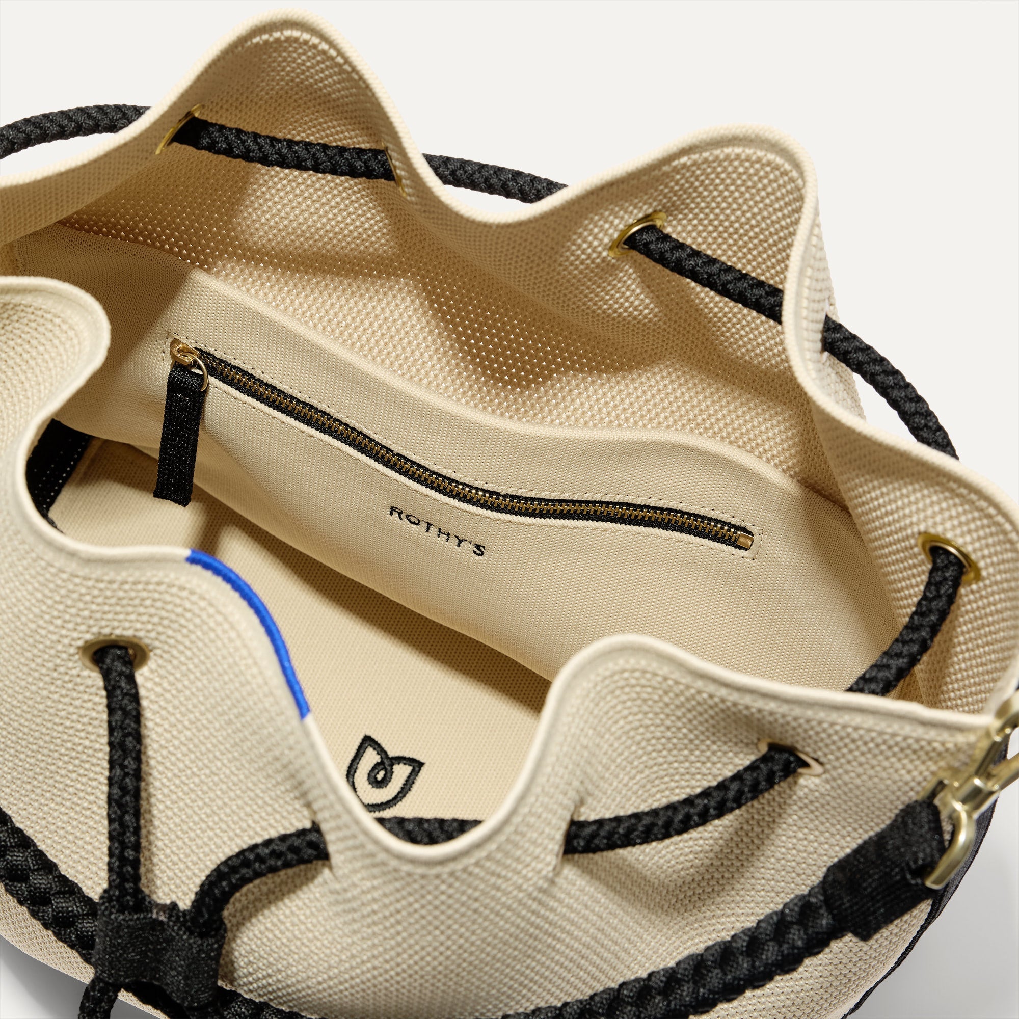 A close up of The Cinch Bucket Bag in Black and White Raffia-Knit showing the interior pockets.