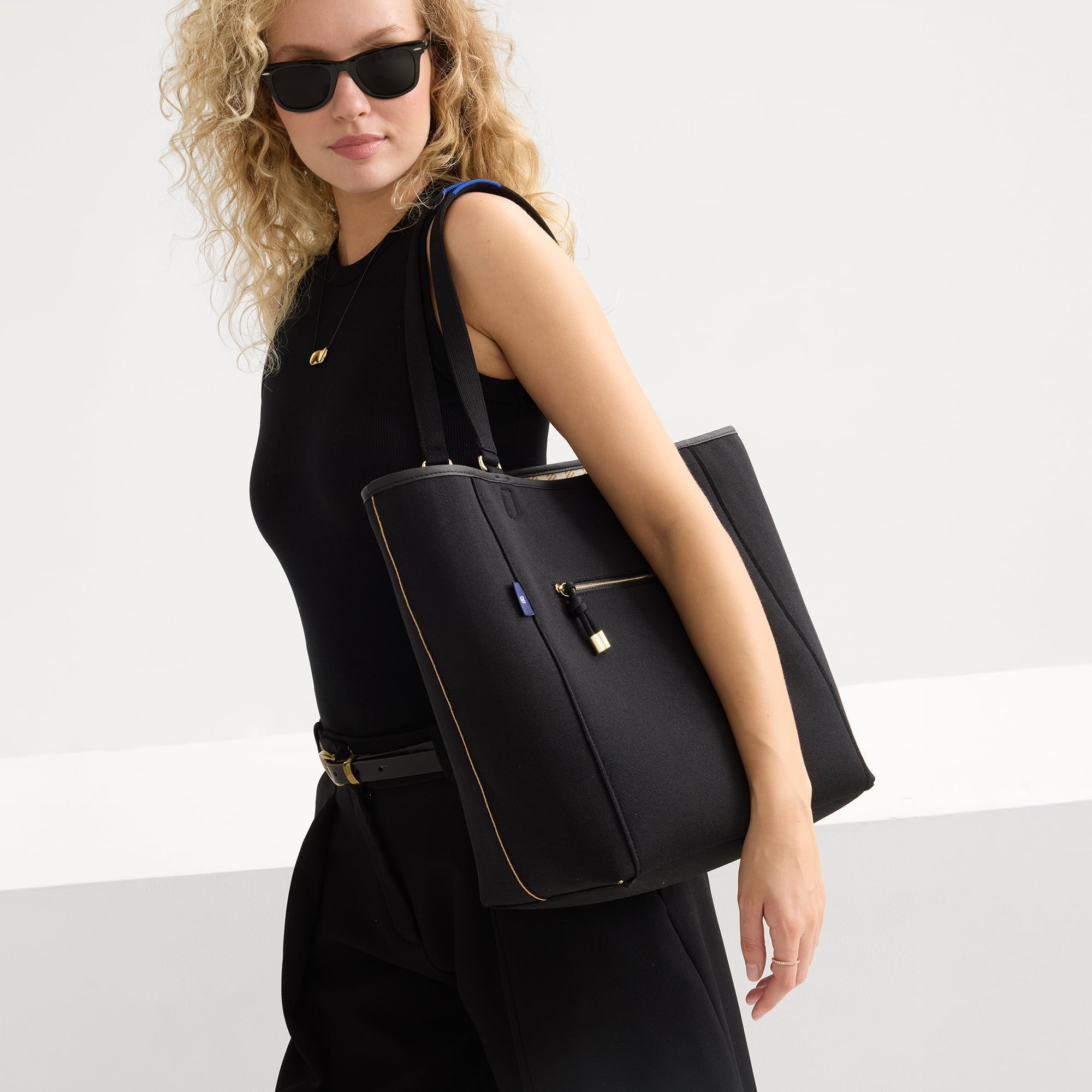 hover | Model carrying The Two-Way Tote in Sandbar showing the solid black side.