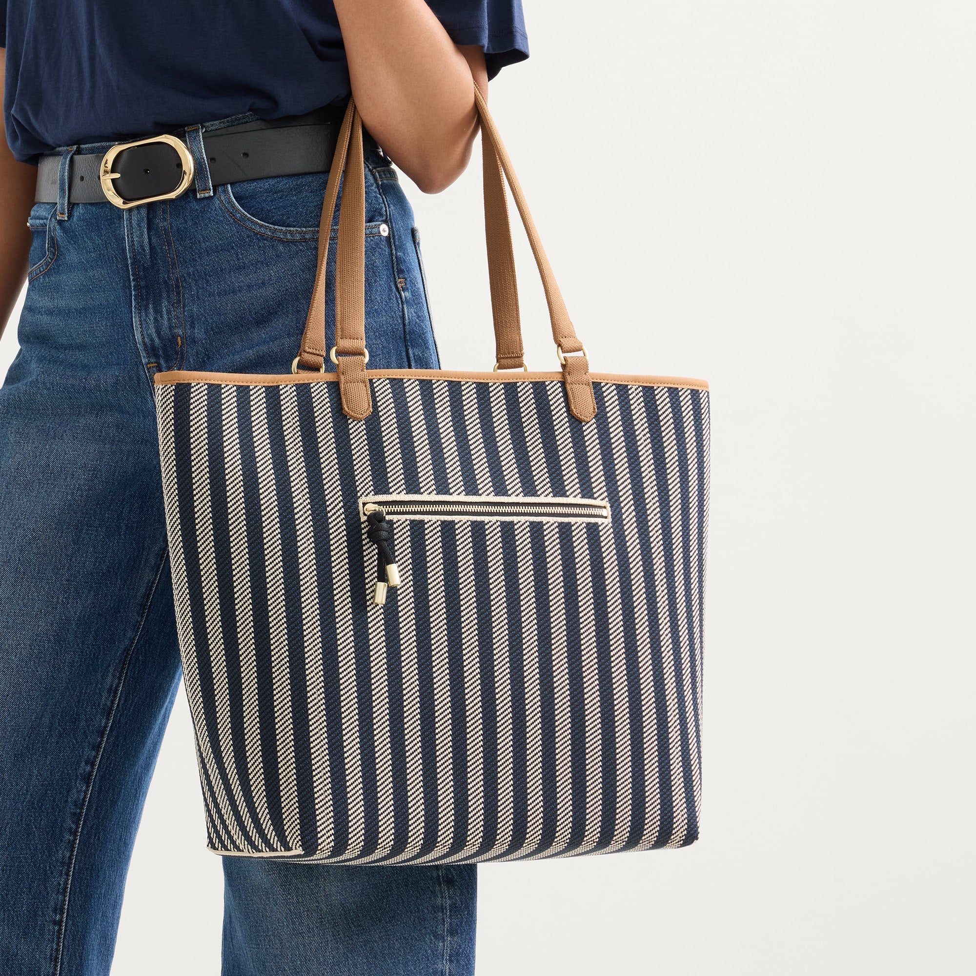 Alternate view of a model carrying The Two-Way Tote in Shadow showing the indigo striped side.
