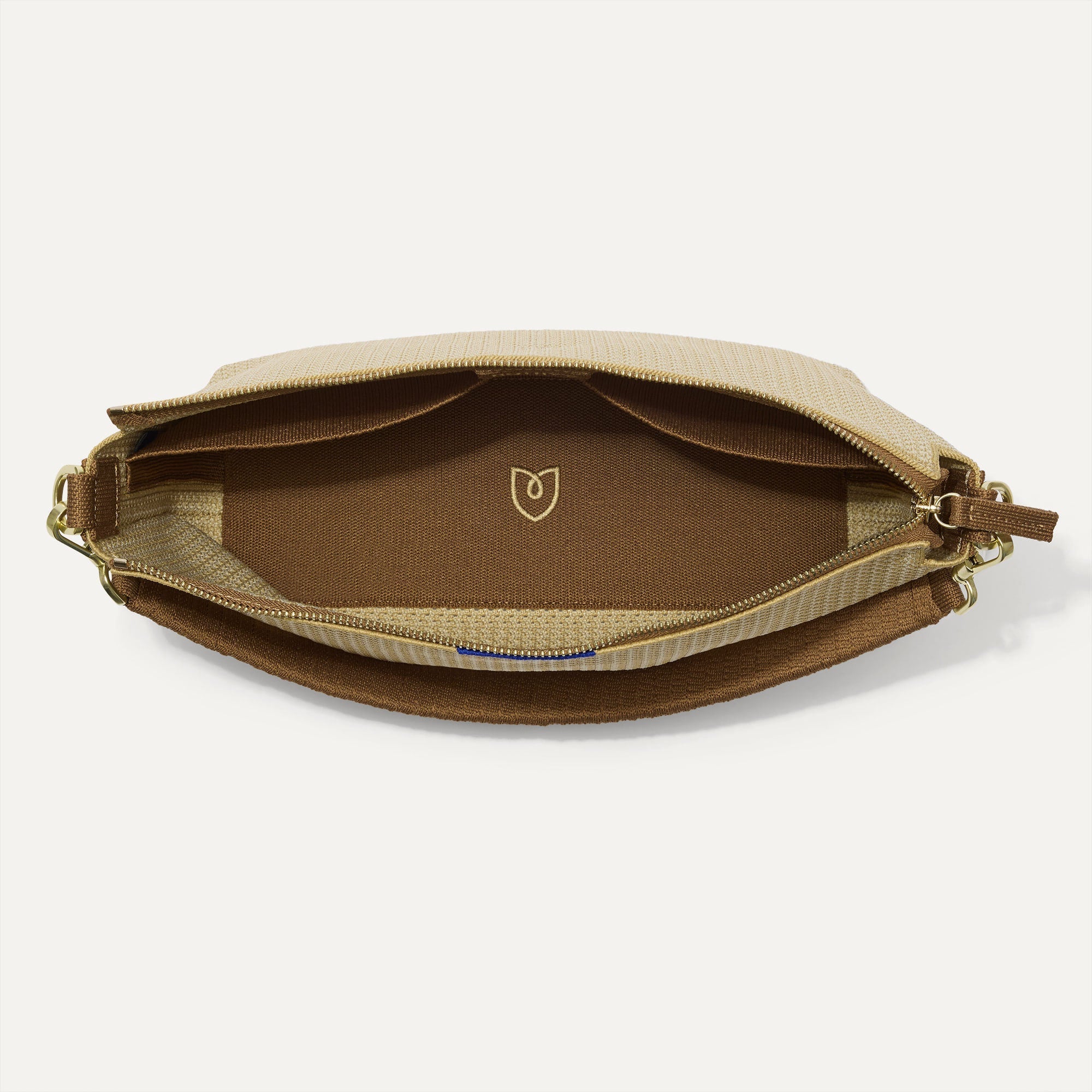 The Daily Crossbody in Macadamia Open-Knit shown from the top down, with zipper open and interior exposed.