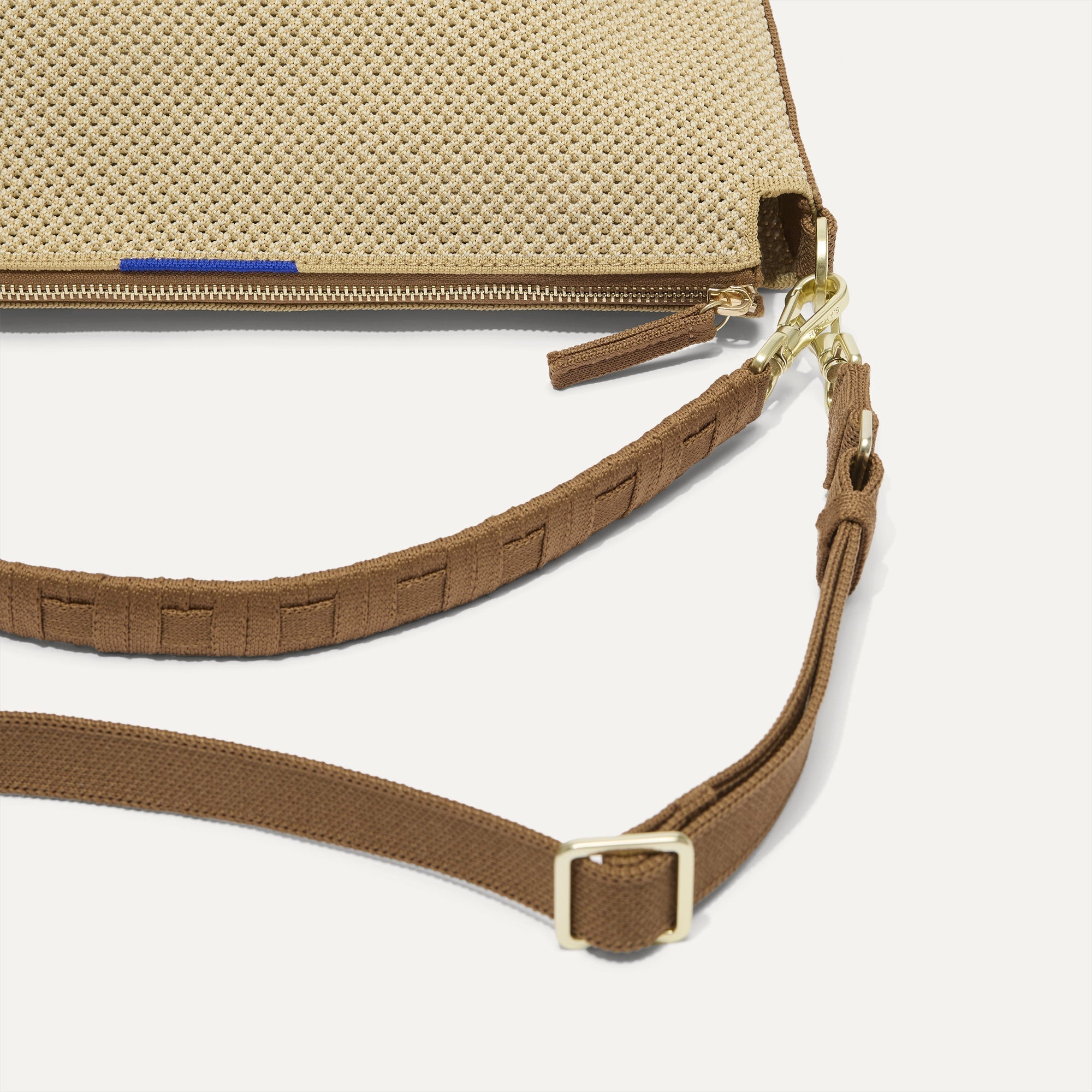 The Daily Crossbody in Macadamia Open-Knit lying flat, showing the detachable top handle and adjustable crossbody strap.