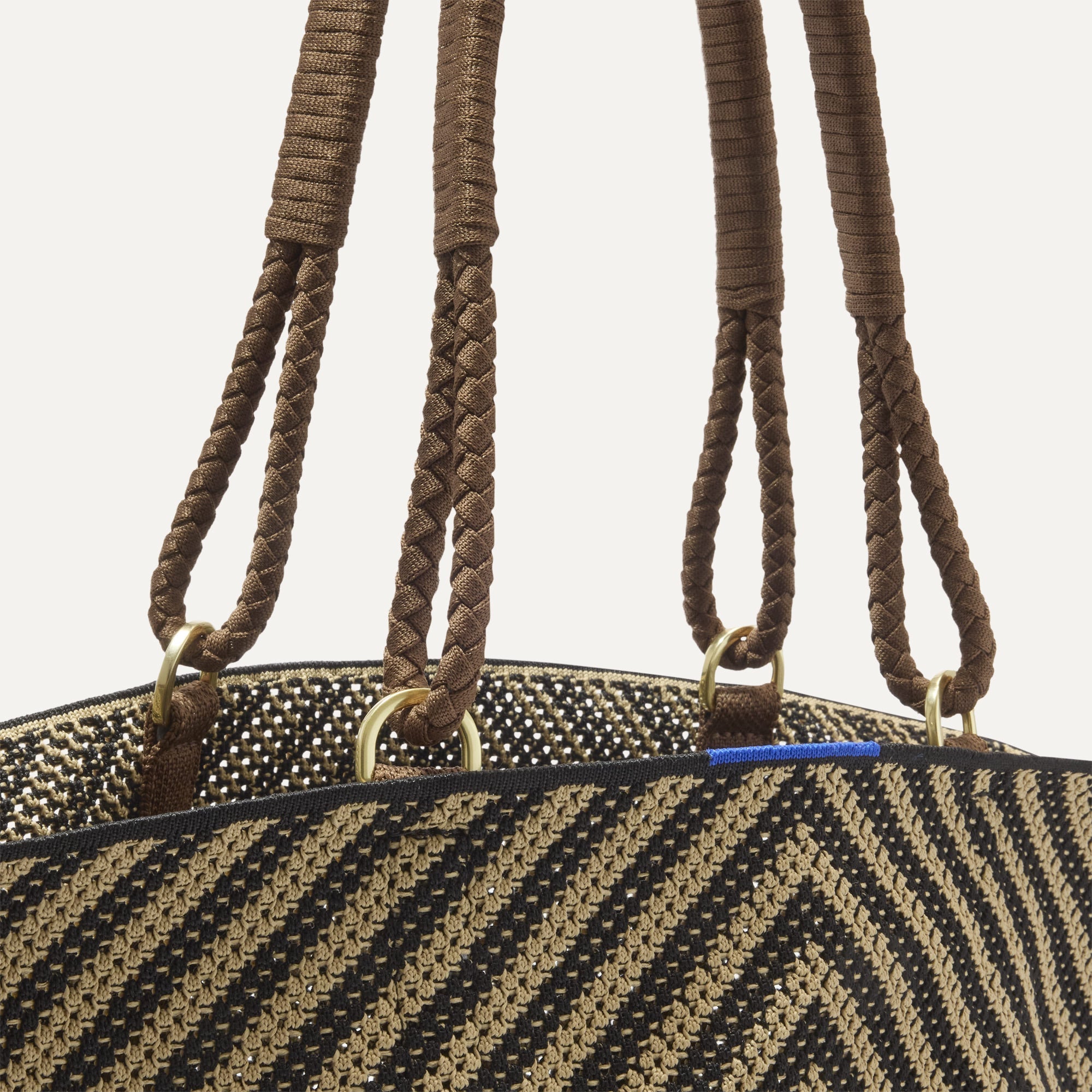 A close up of The Summer Tote in Toffee Chevron focusing on the pocket and handles.