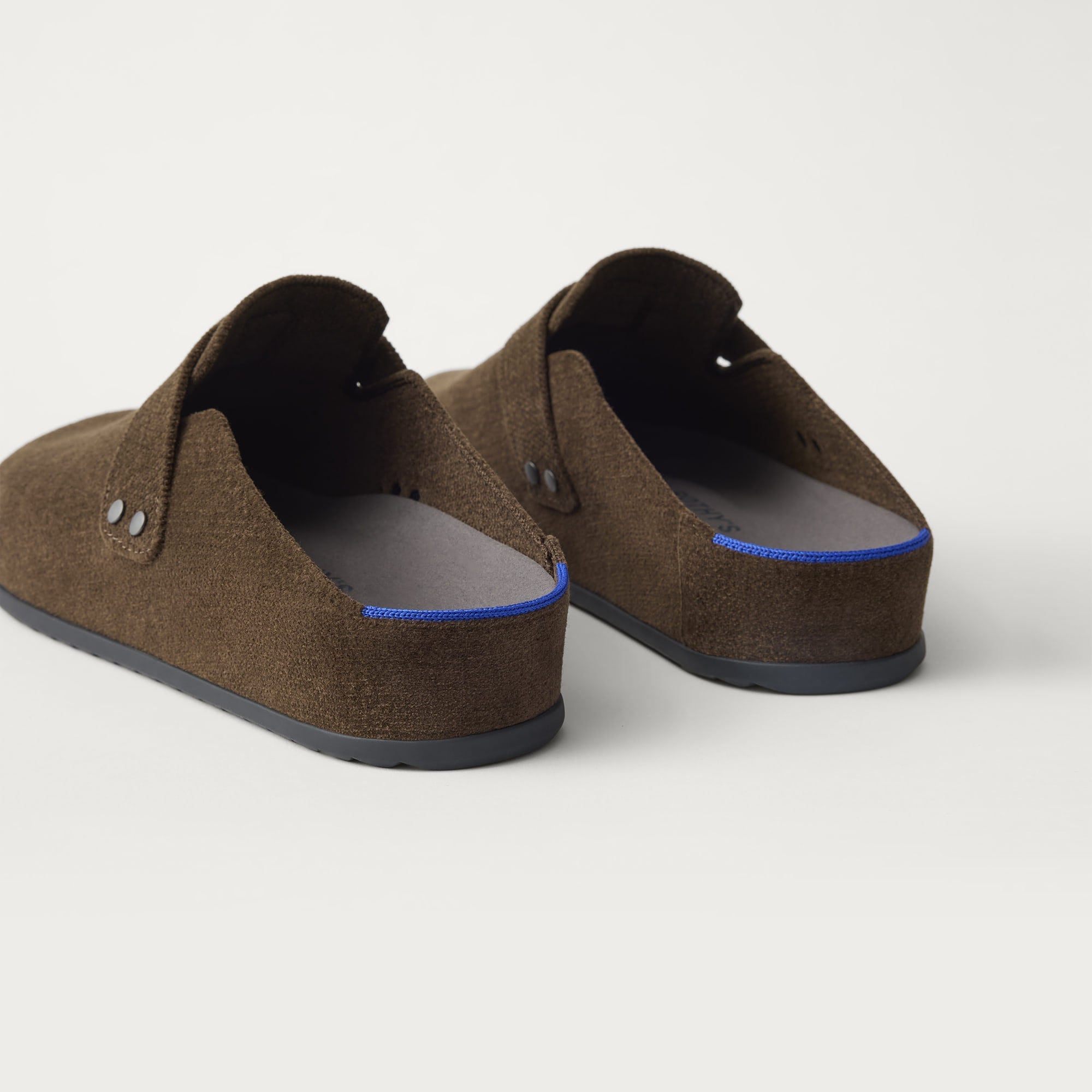 Close up of the heel of The Men's Clog in ReVelvet™ Bistro, with Rothy's signature blue halo. 