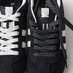 Overlay:: Extra pair of laces included—swap for a new look anytime. | Alt:: Close up of the top of The Ivy Sneaker in ReVelvet Black, showing different lace choices.