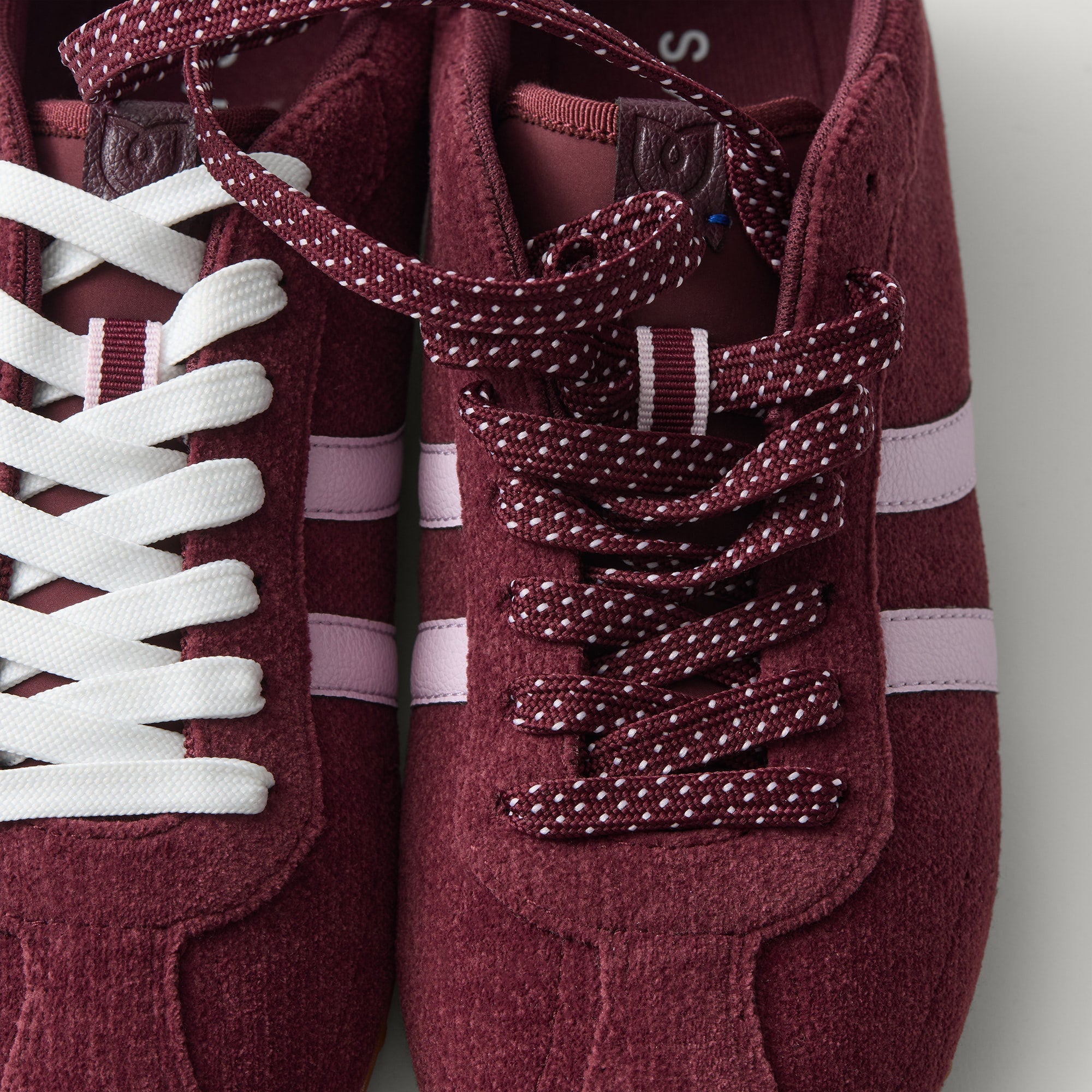 Overlay:: Extra pair of laces included—swap for a new look anytime. | Alt:: Close up of the top of The Ivy Sneaker in ReVelvet Syrah, showing different lace choices.