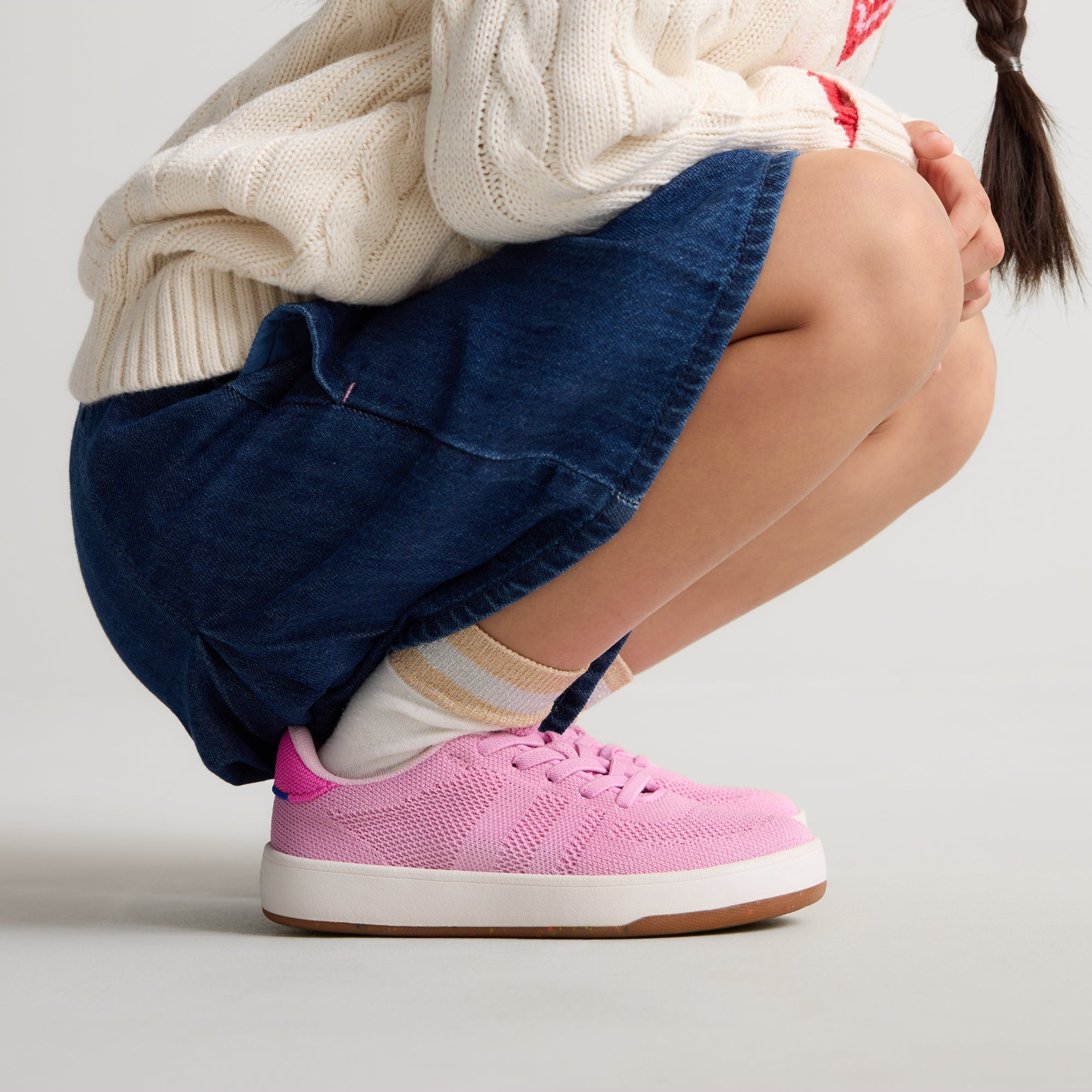 hover | A child modeling The Kids Stretch Sneaker in Bubblegum Pop.