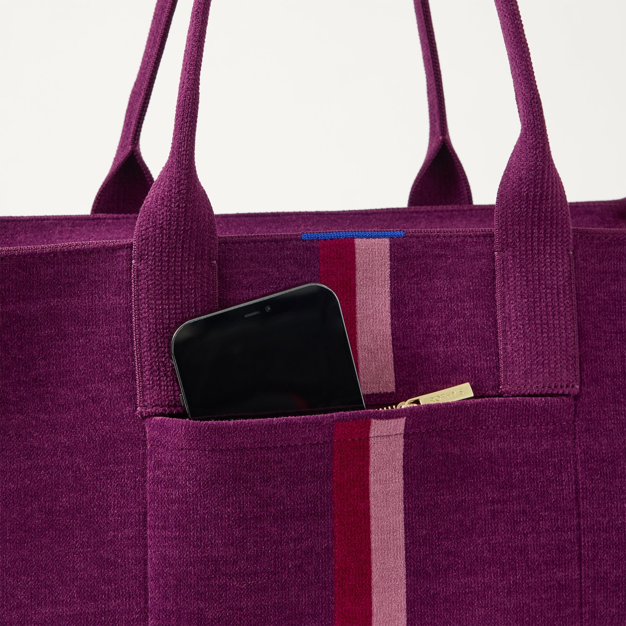 A closeup of The Classic Tote in ReVelvet Orchid, focusing on the exterior zip pocket. 