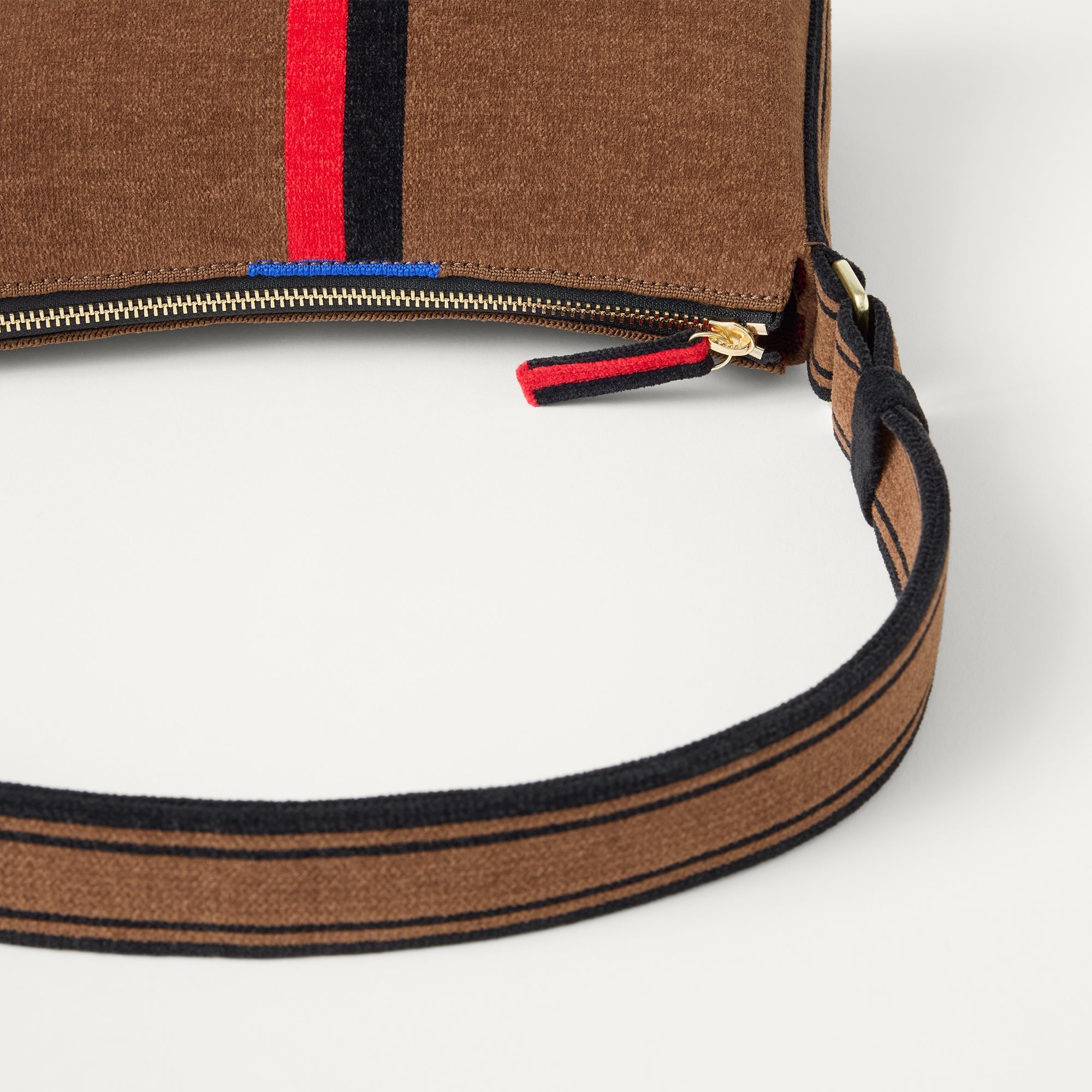 A closeup of The Casual Crossbody in ReVelvet Cinnamon Stripe, focusing on the crossbody strap. 