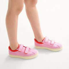 hover | A child modeling The Kids Strap Sneaker in Tutu Open-Knit. 